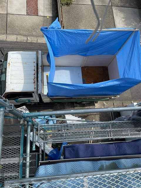 屋根葺き替え工事で古い屋根材などを廃材として回収する車両