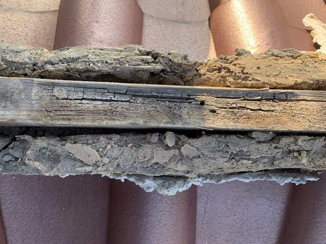 棟瓦を取り除いて垂木が激しく傷んでいる様子