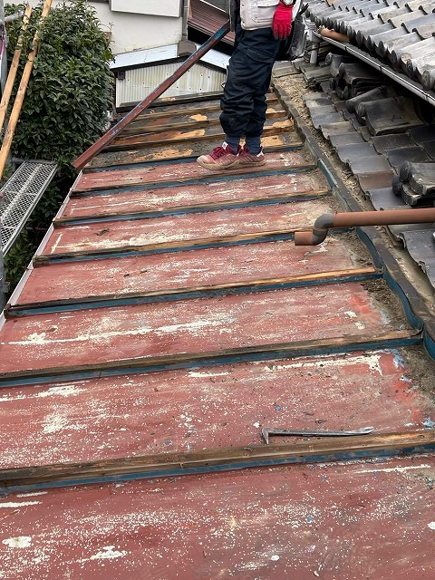 瓦棒葺き屋根のカッパ板金を取り除く様子
