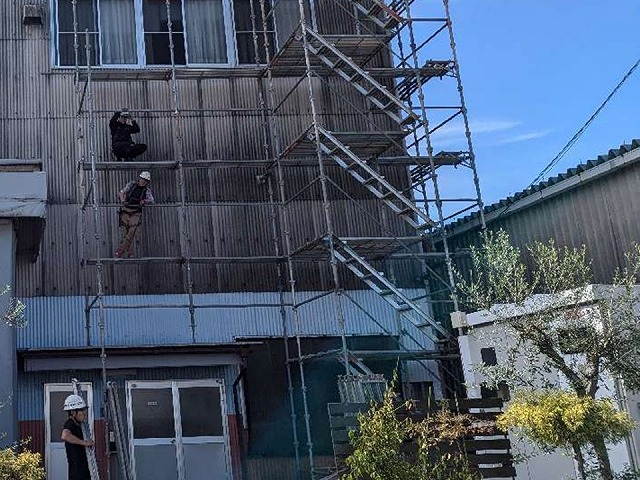 屋根カバー工法による改修工事のための足場を組み立てている状況