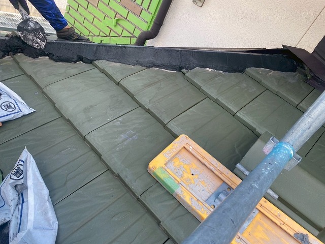 棟瓦取り直し工事でモルロックをコテで成形している様子