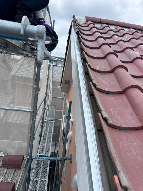 屋根袖瓦取り直し工事の木下地に対するL型鋼板のビス留めの様子