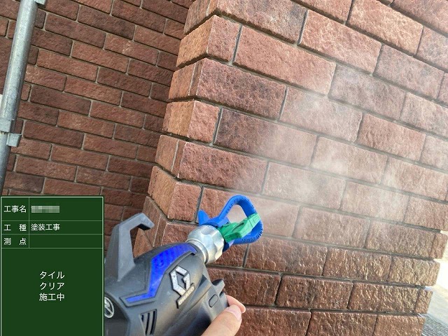 住宅外壁塗装工事のタイル外壁への吹き付けクリア塗装1回目