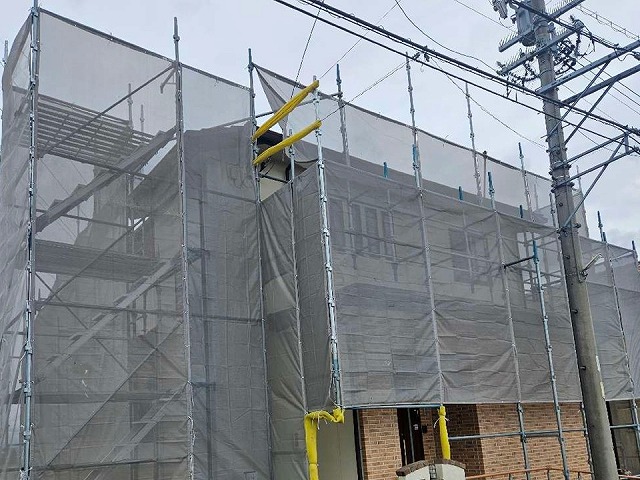 役物取り替え工事の足場組み立て後のメッシュシート張り
