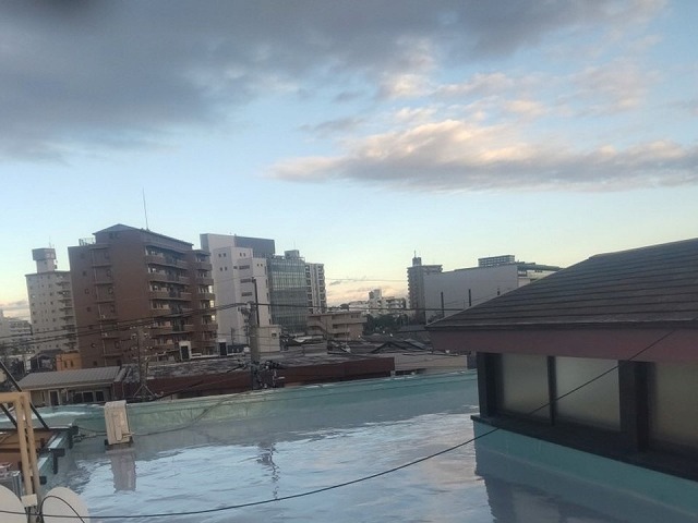 陸屋根の屋上でウレタン塗膜防水工事を行っている様子