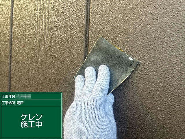 雨戸の表面をサンドペーパーでこすってケレンを行っている施工中の様子