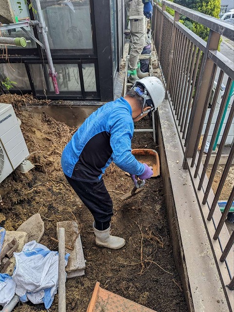 雨漏りの原因となっているベランダの植栽や土をスコップで撤去