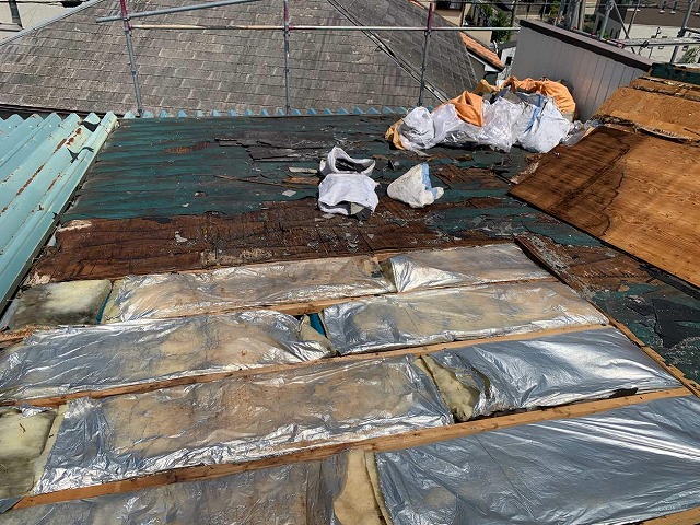 スレート屋根の下に充填していた断熱材が濡れて傷んでいる様子