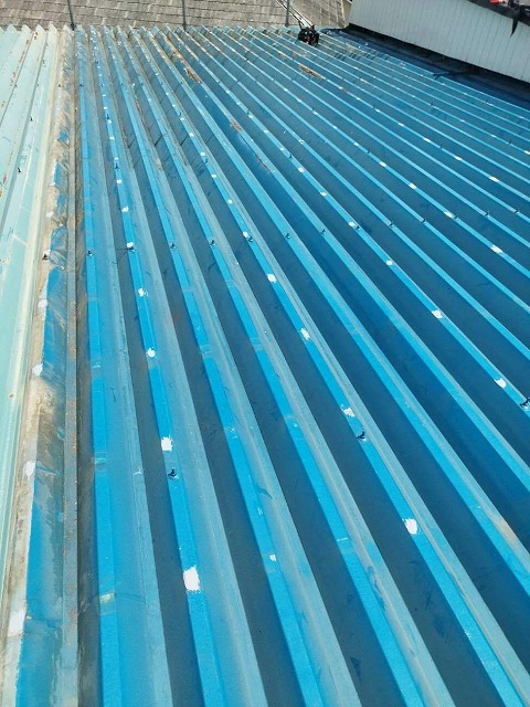 折板屋根のビス穴のコーキングによる補修が完了した様子