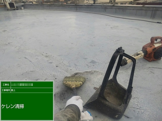 店舗建物の屋上防水工事のケレンの後に行う清掃の様子