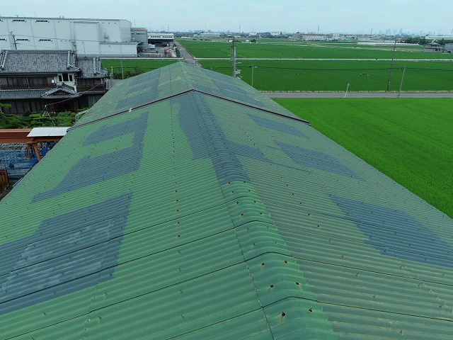 緑色に塗装した波型スレート屋根の工場建物