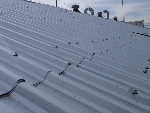 屋根カバー工法による改修工事の折板屋根を専用ビスで固定