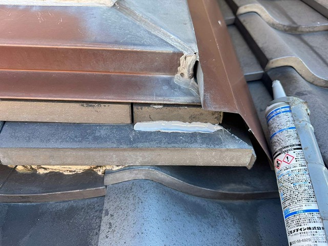 経年劣化により抜け落ちたのし瓦をコーキングで接着して復旧