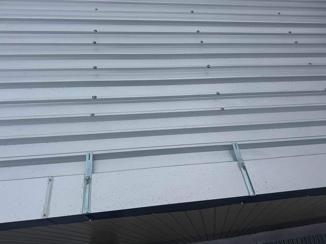 倉庫屋根カバー工事でケラバ押さえ金物の取り付けが完了