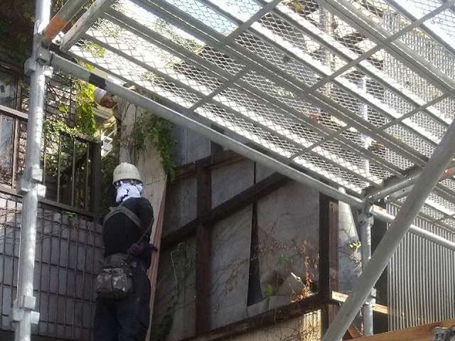 劣化で傷んだ塩ビ波板を張り替えするために取り外している様子