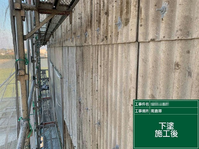 工場建物の庇の波型スレート外壁塗装工事の下塗りが完了した状況