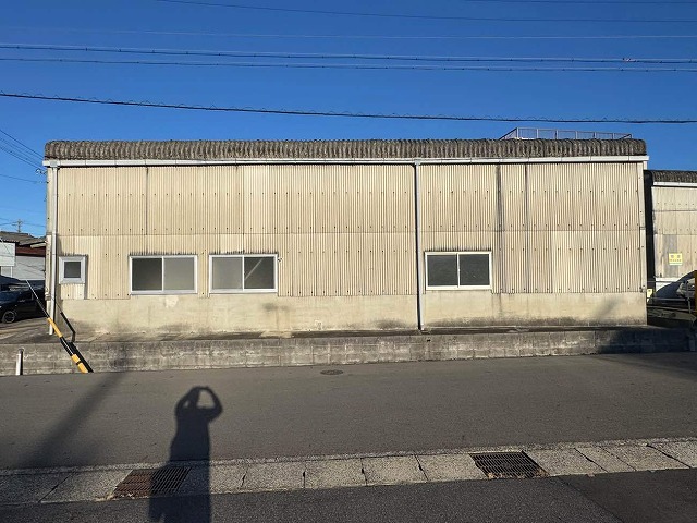 既存波型スレートにカバー工法メンテナンスを行う倉庫建物