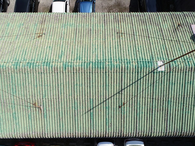 経年劣化で緑色の塗装が剥がれ落ちているスレート屋根