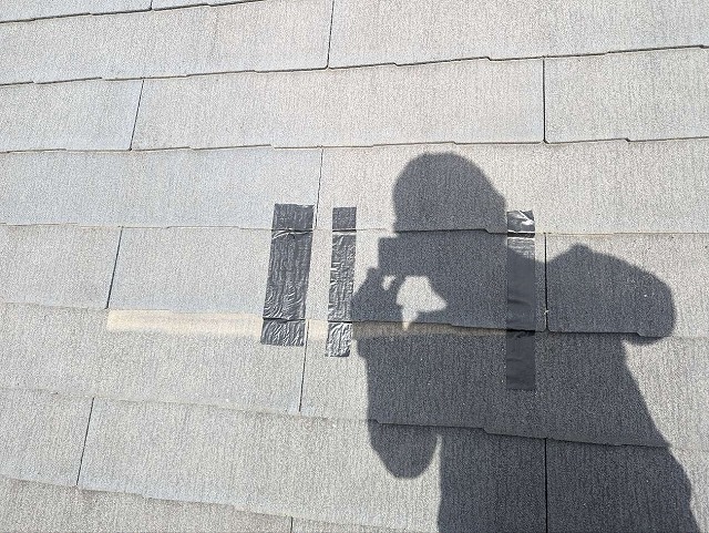 スレート屋根の割れやズレをテープで応急処置している様子