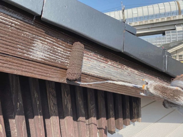 木製の破風板にローラーで塗装している様子