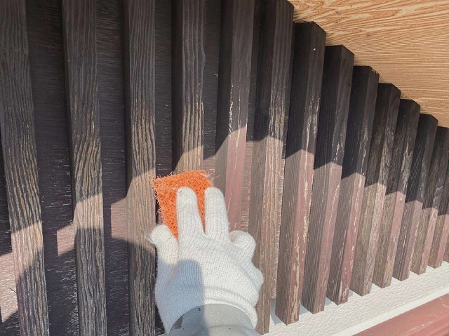 木部へのケレンで古い塗膜やケバ立ちなどを取り除いている様子