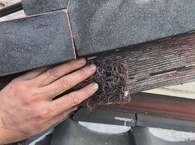 住宅の破風板に塗装前のケレンを行っている様子