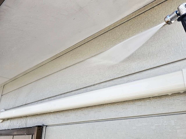 金属サイディングの汚れなどを落とす高圧洗浄作業