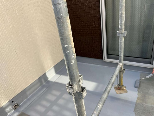 ベランダ床面にトップコートの重ね塗りを行っている様子