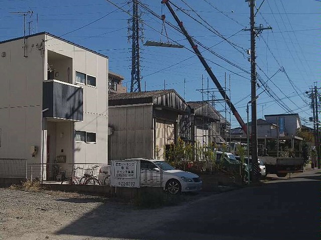 貸倉庫の折板屋根カバー工事の搬入でクレーン車を現場敷地内に配置している様子