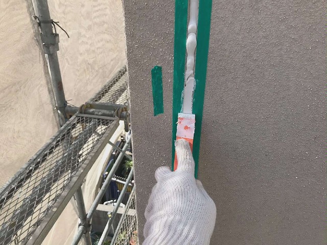 コーキング打ち替え工事で新規コーキングをヘラ押さえ