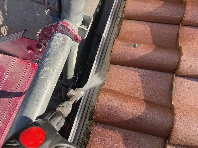 屋根上から雨樋の内部を高圧洗浄