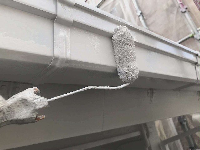 劣化した雨樋への塗装を行っている様子