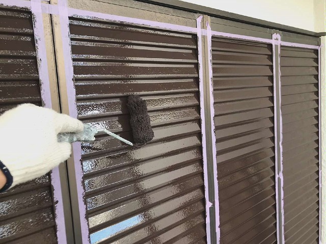 シャッターに茶色で塗装している様子