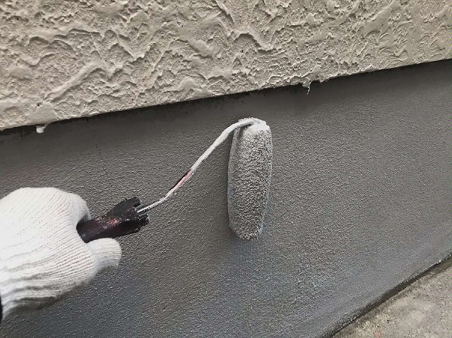 ひび割れていた基礎への塗装を行う塗装工