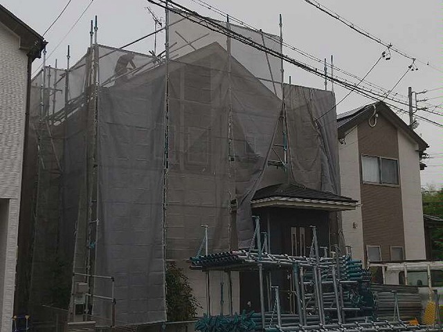 足場設置完了後に屋根の上で作業を行う屋根職人