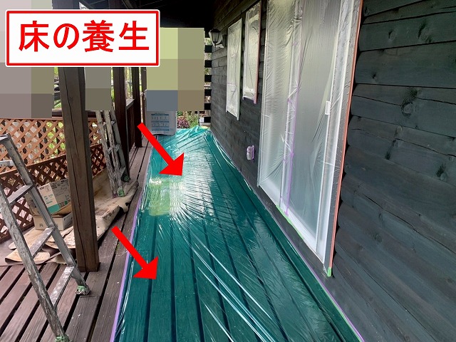 北杜市で別荘（ログハウス）の外壁塗装時に床に養生をかける様子