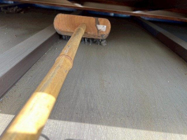 大月市で瓦棒葺きトタン屋根をデッキブラシでケレン作業（手作業）する様子