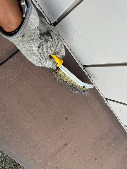 大月市で瓦棒葺きトタン屋根をワイヤーブラシでケレン作業（手作業）する様子