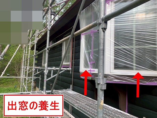 北杜市で別荘（ログハウス）の外壁塗装時に出窓に養生をかける様子