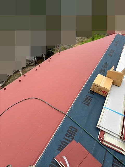 都留市でスレート屋根から断熱材入りSGL鋼板（GMルーフ）にカバー工法を行う様子