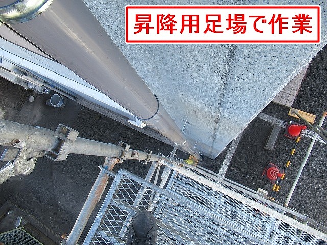 甲斐市で昇降用足場を仮設して雨樋工事を行う様子