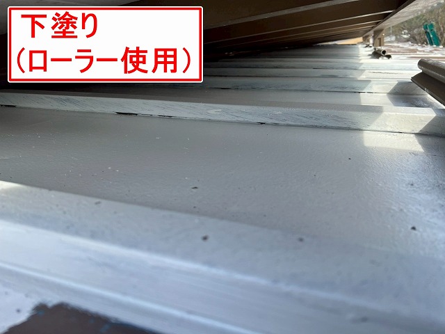 大月市でローラーを使用して金属屋根（トタン屋根）にサーモアイプライマーで下塗りを行う様子