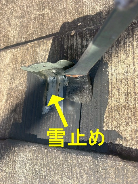 甲府市で屋根塗装の際に雪止めを刷毛を使用して塗装する様子