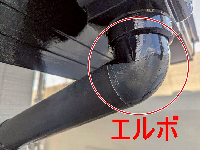 甲府市で雨樋（竪樋・エルボ）にケレン・目粗し・無機塗装を行う様子