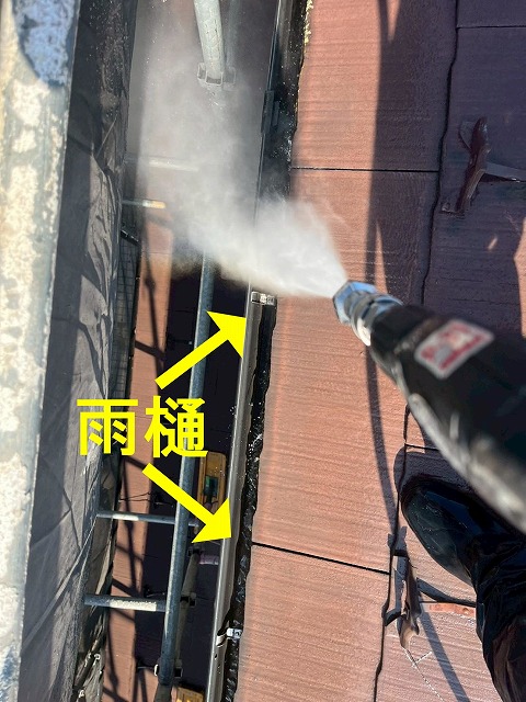 笛吹市でカバー工法前のコロニアル屋根に高圧洗浄を行う様子（雨樋の清掃）