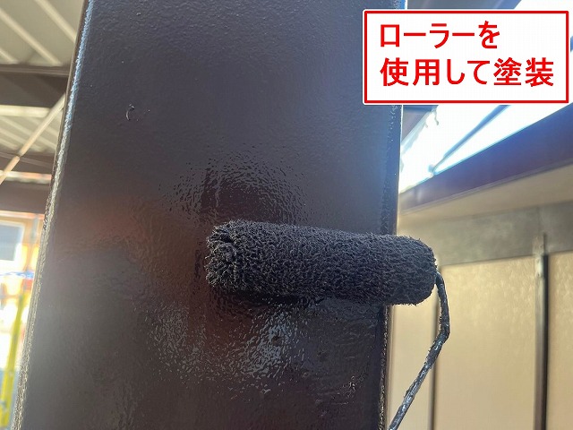 富士吉田市で折板カーポートの鉄骨をローラーを使用して塗装する様子