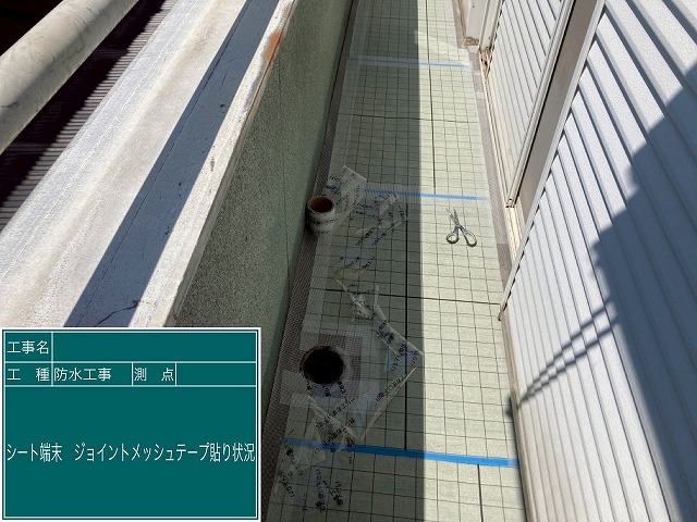 甲府市でベランダ防水（バルコニー防水）にシート端末にテープ貼り付けを行う様子