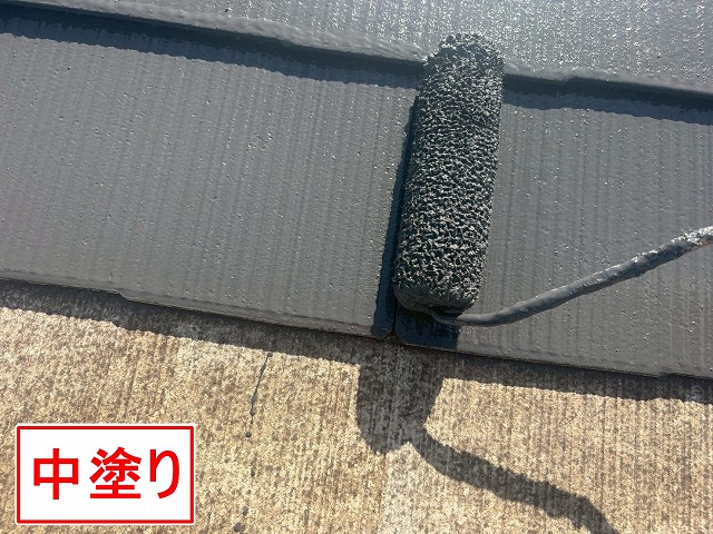 甲府市で屋根塗装の際にローラーを使用して中塗りする様子