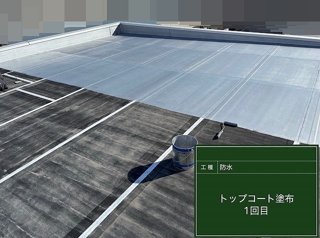 甲斐市で屋上シート防水にトップコートを塗布する様子