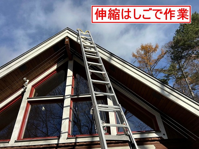 北杜市でキツツキの穴が開いた軒天を伸縮梯子で補修する様子
